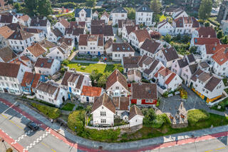 Aerial view of traditional wooden houses with red-tiled roofs in Old Stavanger, Norway, captured from the top deck of a cruise ship.