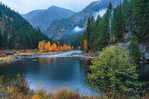 Fine art landscape photograph of Tumwater Canyon near Leavenworth, Washington, showing misty mountains, golden autumn trees, and reflections.